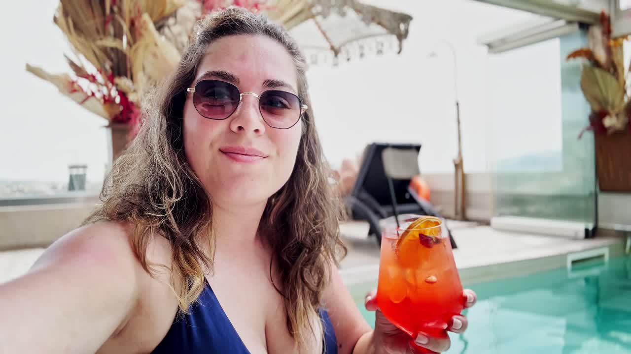 Woman enjoying a cocktail by the rooftop pool