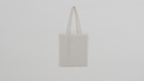Close-up-of-white-bag-on-white-background,-copy-space,-slow-motion