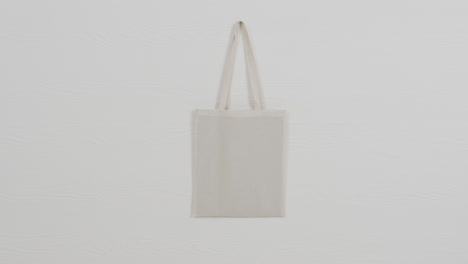 close up of white bag on white background, copy space, slow motion