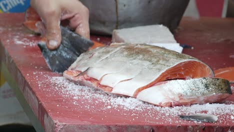 butcher cutting fresh salmon fillet