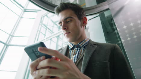 joven empresario que usa un teléfono inteligente en el ascensor