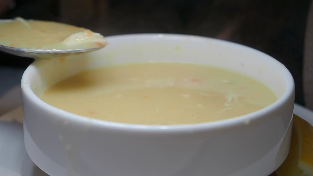 Close-Up of Hot Creamy Soup Being Stirred with a Spoon
