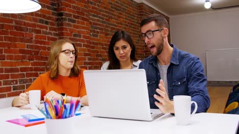 grupo de ejecutivos discutiendo sobre computadora portátil en la sala de conferencias