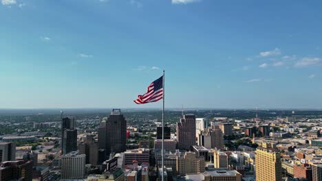 Aerial-tilt-up-US-flag-flying-proudly-atop-the-Tower-Life-Building-in-San-Antonio