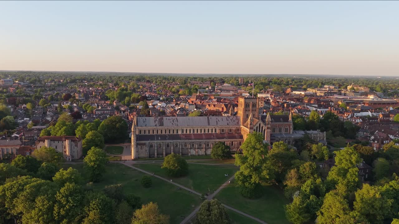 A cinematic drone rises over St Albans Park, tilting down to reveal the majestic cathedral and the expansive park landscape in a stunning aerial view