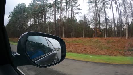 conduciendo por una carretera y a través de un bosque - hiperlapso del punto de vista del pasajero por la ventana con vista al espejo retrovisor