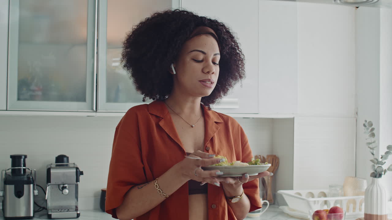 Latin Woman in Earphones Eating Salad and Talking with Friend