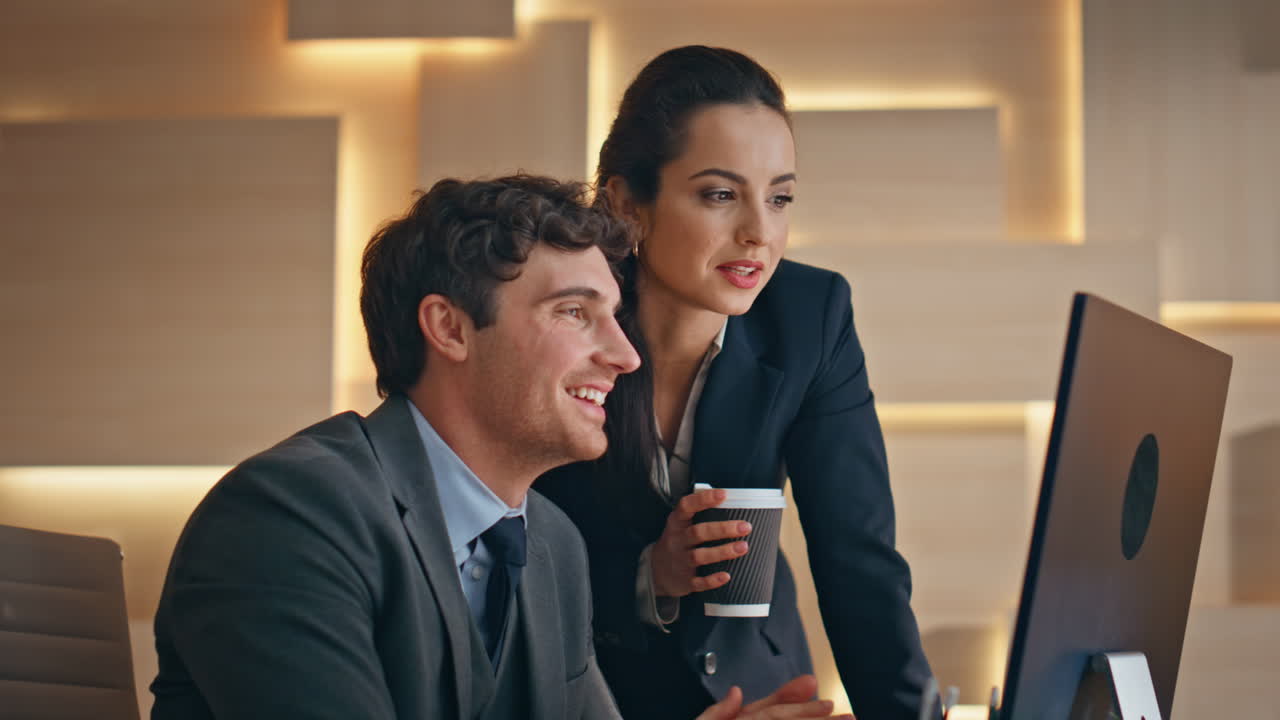 Happy colleagues watching computer screen at cabinet closeup. Coworkers working