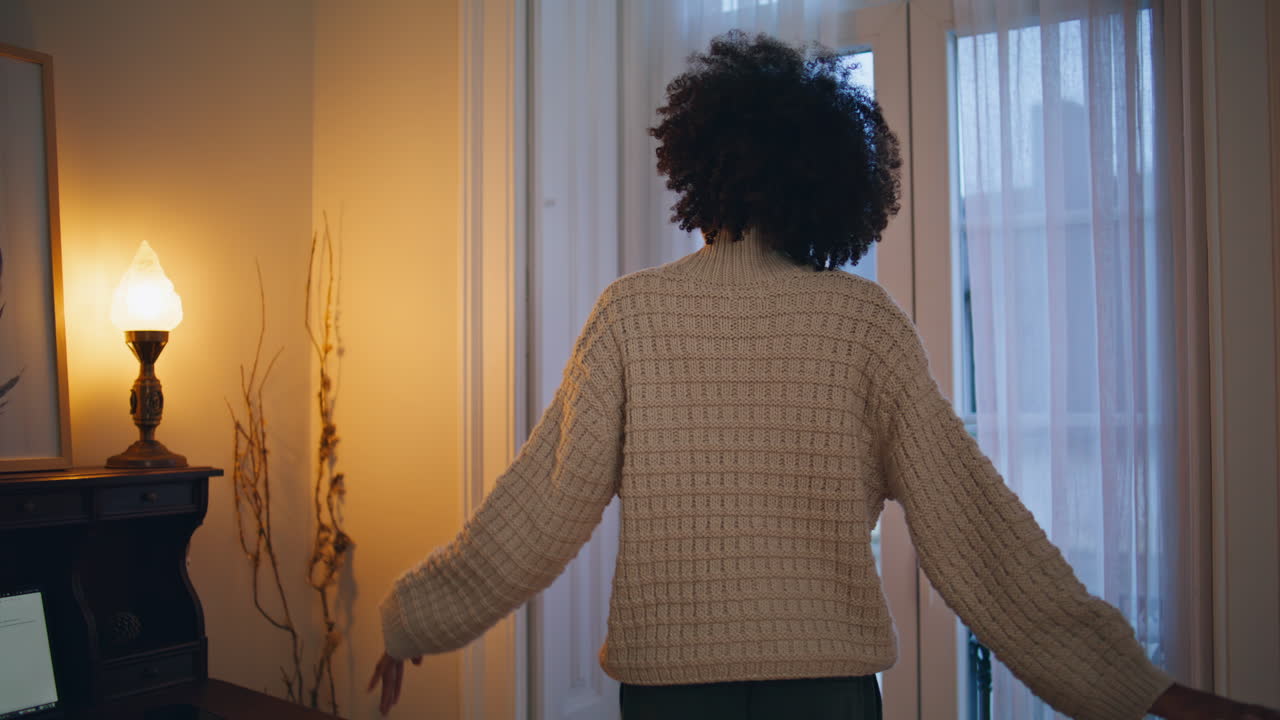 Modella felice che balla con le cuffie, al chiuso. Primo piano di una ragazza africana che ascolta musica.