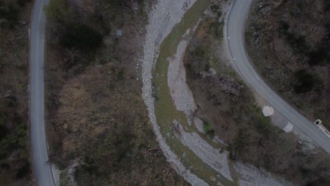 Top-view-aerial-shot-with-a-drone,-flying-over-a-river-and-country-roads-|-4K