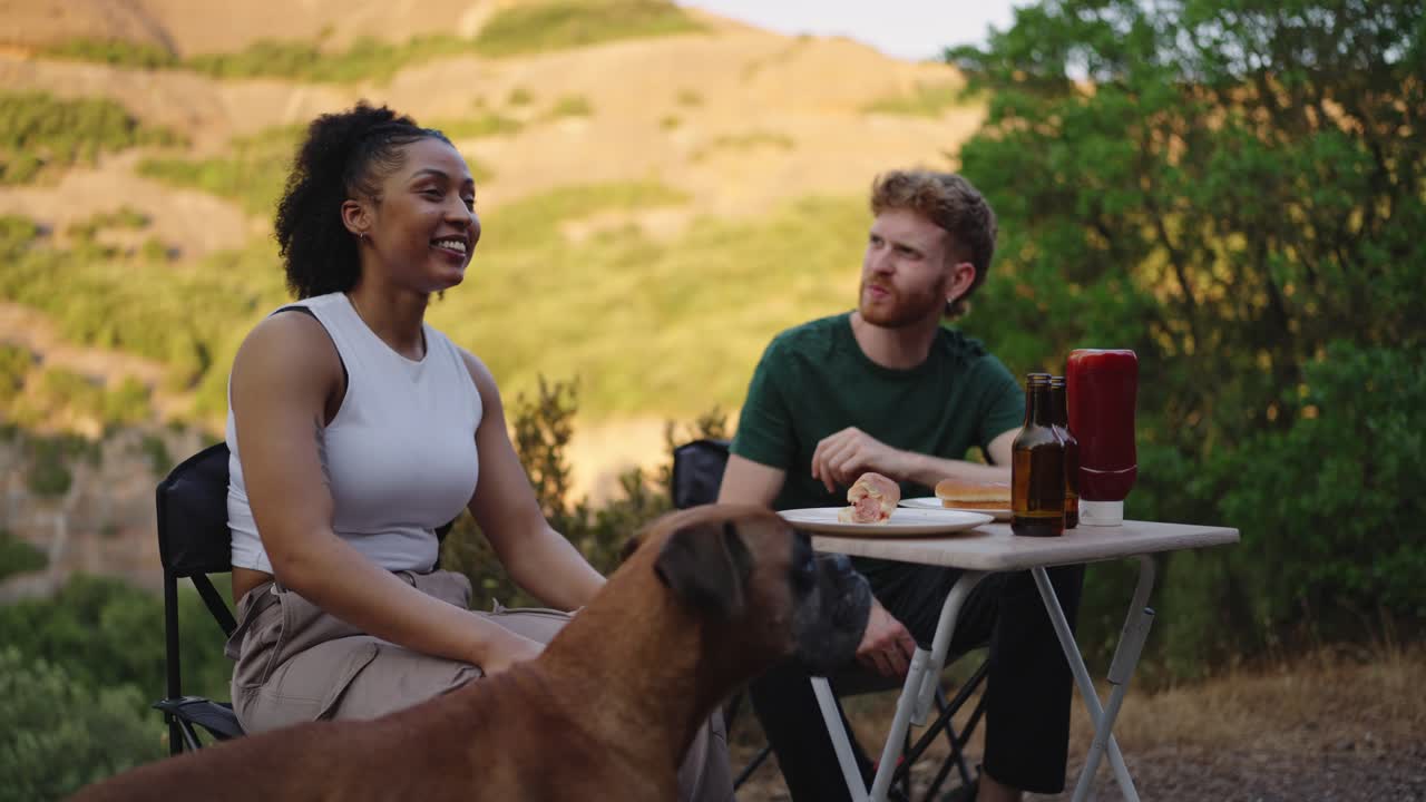 Couple enjoying a picnic with their dog outdoors