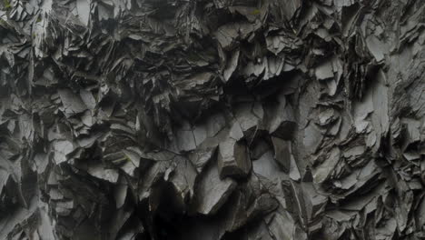 rocky wall with unique hexagonal pattern in a wet cave in iceland