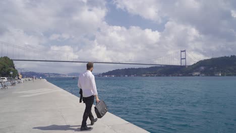 Hombre-De-Negocios-Caminando-Por-La-Orilla-Del-Mar.