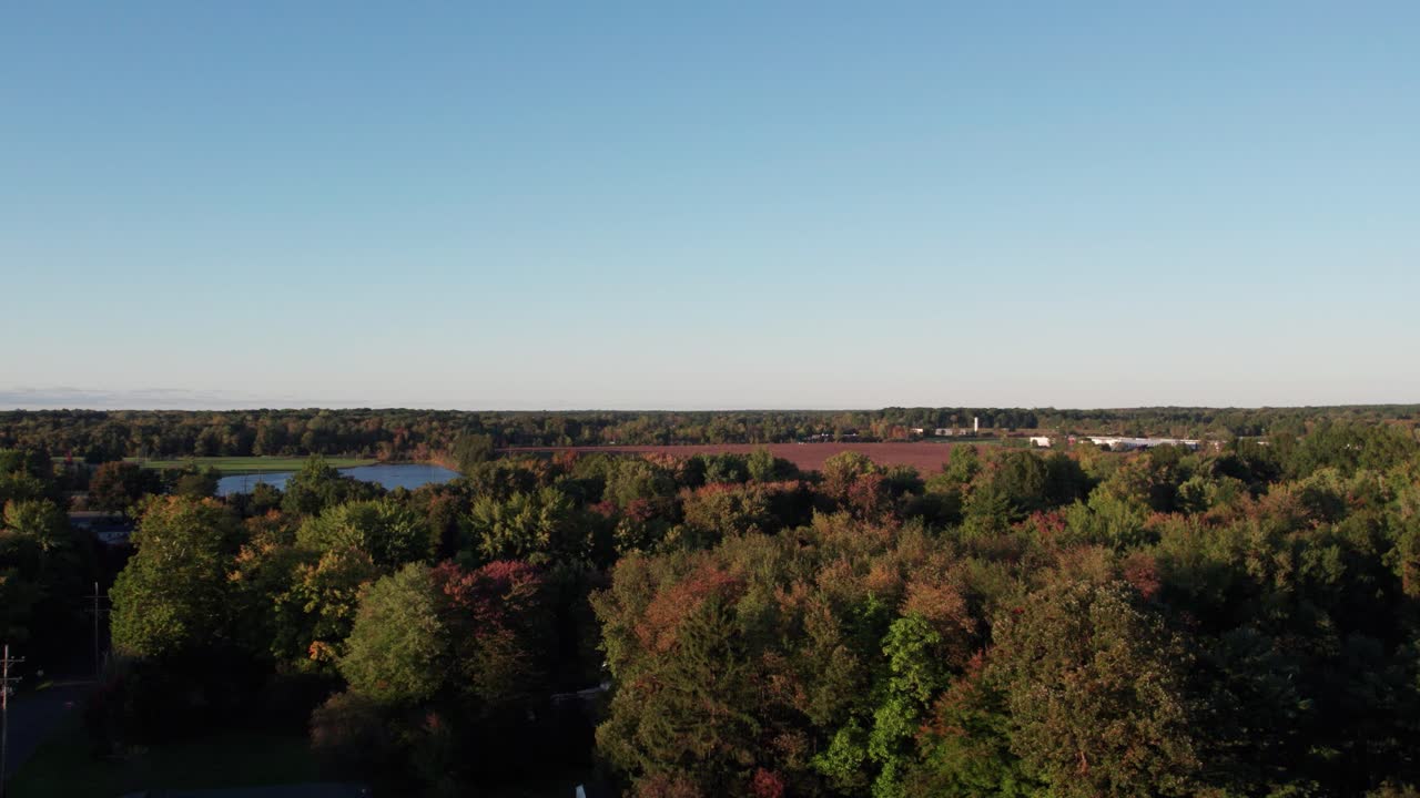 vista aérea de drones sobre casas de pueblo rodeadas de vegetación verde y embalses durante la noche