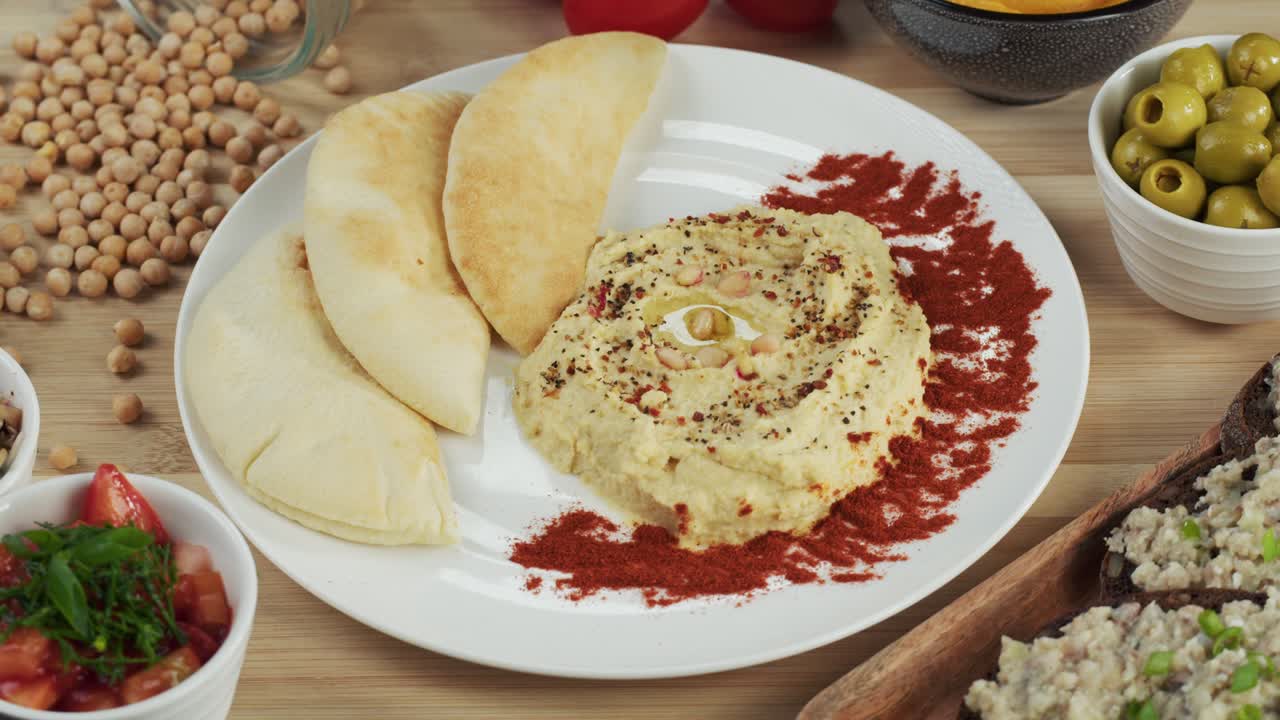 cocina israelí. hummus decorado con pimentón y pita en un plato de primer plano. comida nacional, cultura de oriente medio. bocadillo de puré de garbanzos vegano. aperitivo hecho de puré