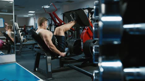 Un-Joven-Atleta-Entrena-Sus-Piernas-En-El-Gimnasio.