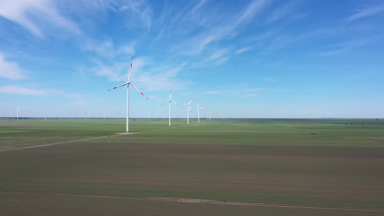 View of several windmills, wind generators, turbines, producing renewable clean energy by converting kinetic energy