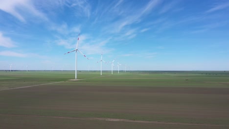 view of several windmills, wind generators, turbines, producing renewable clean energy by converting kinetic energy