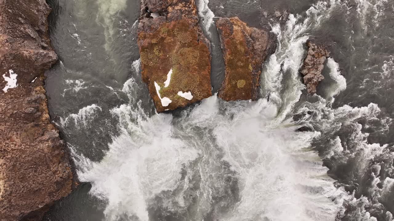 Top-down view captures the churning, dynamic water slopes of Goðafoss, the "Waterfall of the Gods," as the Skjálfandafljót river plunges over its rugged basalt formations near Laugar, Iceland.