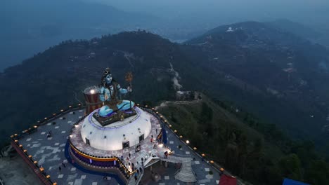 Side-angle-view-of-shiva-statue-in-pumdikot-nepal,-drone-aerial-rising