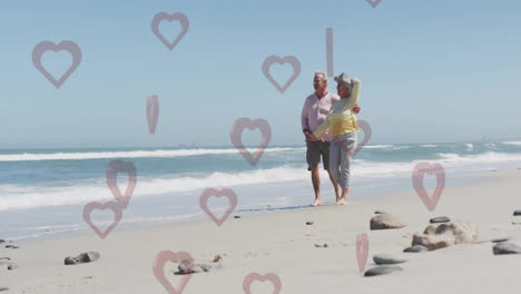 walking on beach, elderly couple with animation of heart shapes floating