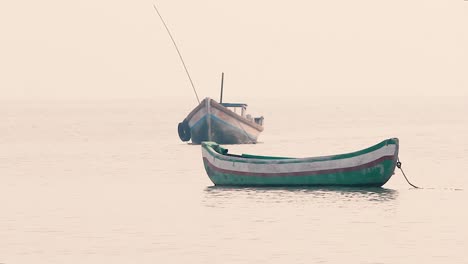 Small-wooden-boat-bobs-and-swings-on-calm-waves-in-sea-without-people-or-sailor,-a-small-boat-near-a-beach-shore-without-a-people-in-calm-waves-background-video-mov-in-full-HD