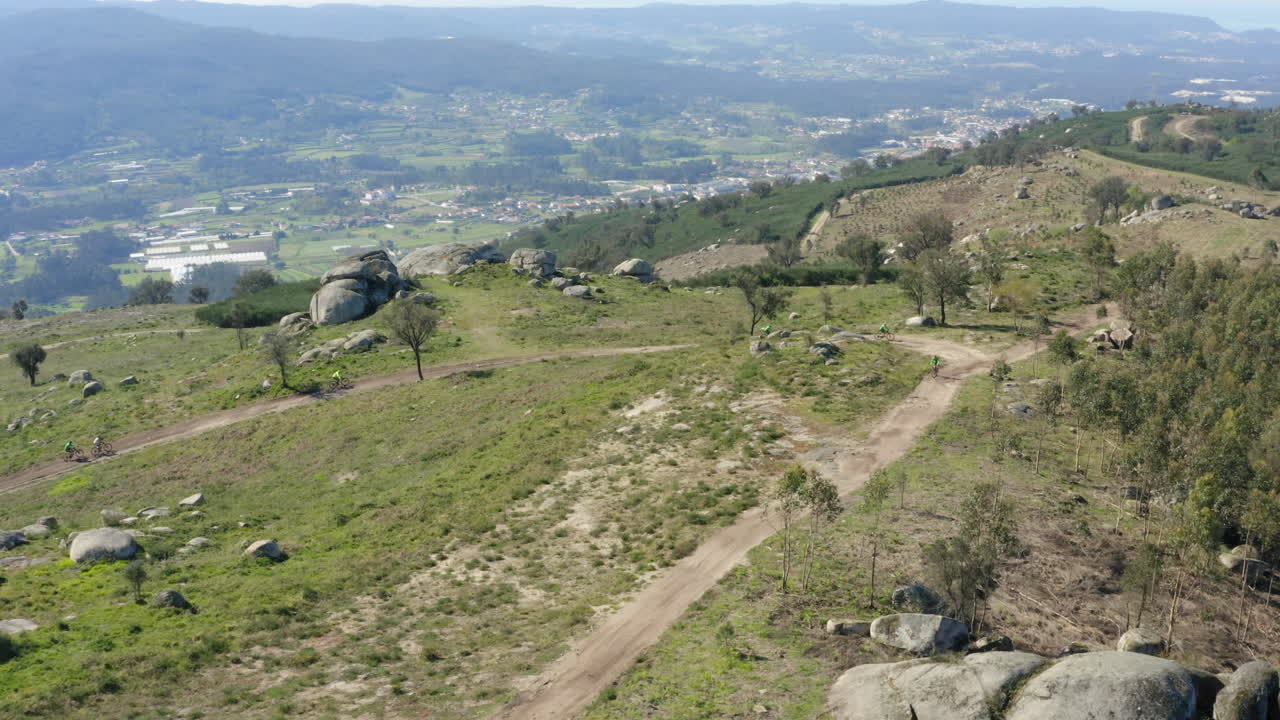 sendero cuesta arriba que está siendo escalado por un grupo de ciclistas de montaña en minho, portugal - sobrevuelo aéreo encuentro tiro de seguimiento