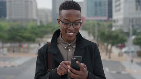 portrait young african american business man student using smartphone in city texting browsing messages on mobile phone enjoying professional urban lifestyle slow motion