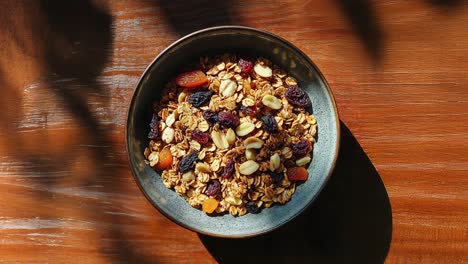 primer plano de un tazón de granola con pasas, nueces y albaricoques secos en una mesa de madera