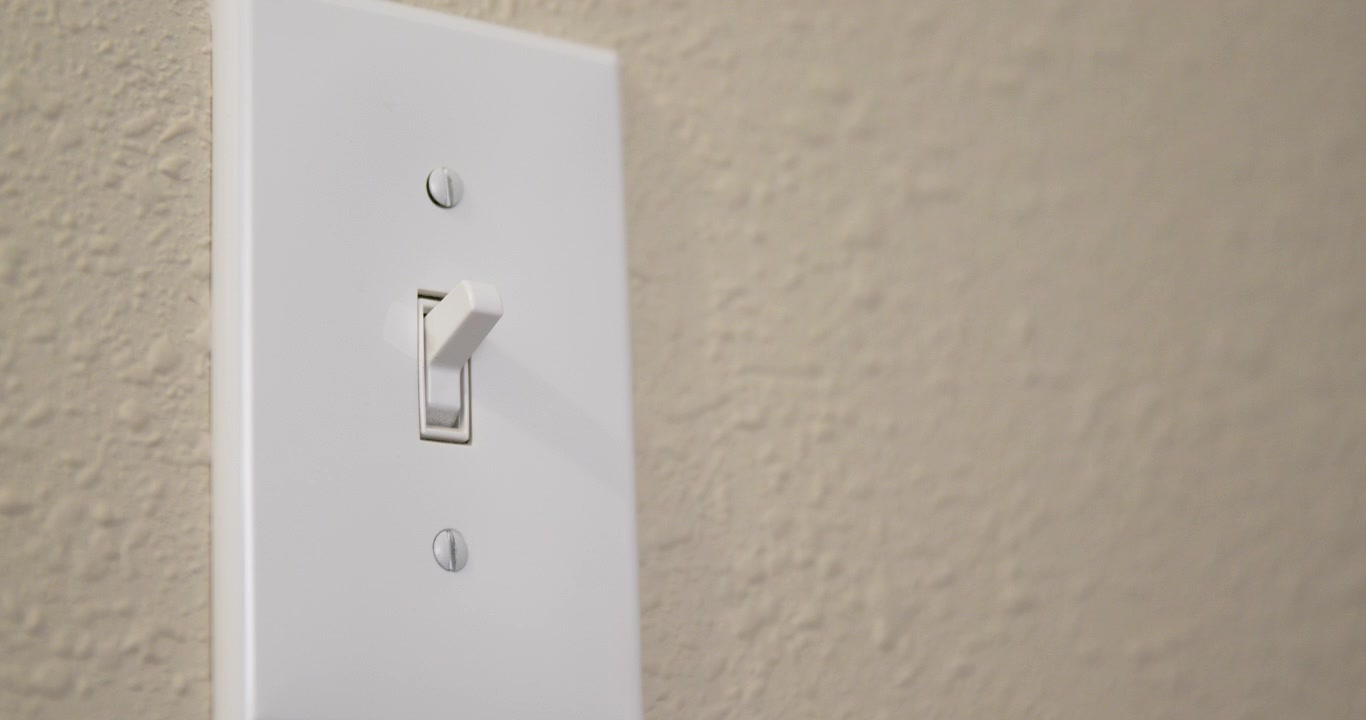Man's Hand Turns Light Switch Off then On 02