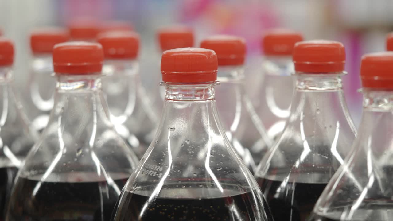 Fileiras de Garrafas Plásticas de Refrigerante com Tampas Vermelhas