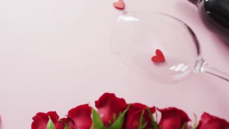 Rote-Rosen-Und-Weinglas-Mit-Flasche-Auf-Rosa-Hintergrund-Am-Valentinstag