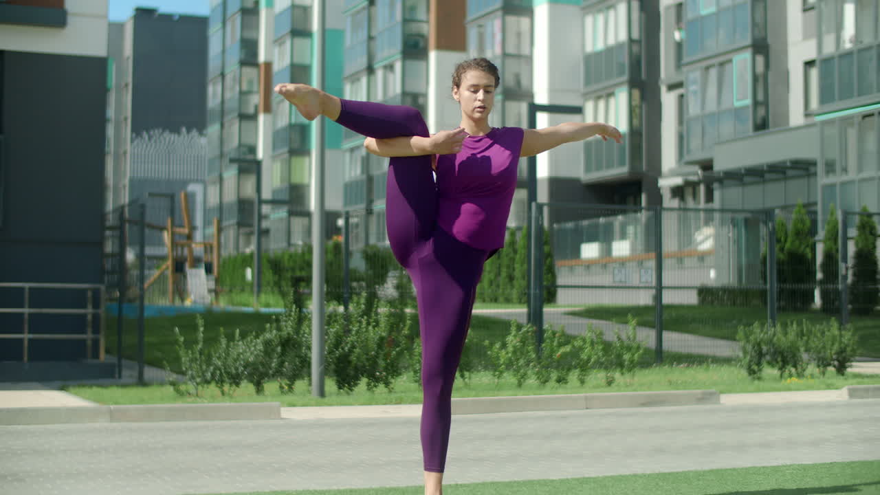 Woman practicing yoga outdoors in an urban setting