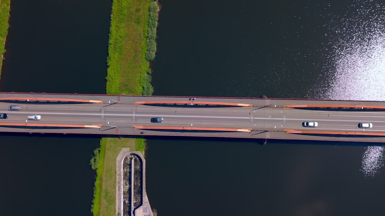 Top-down aerial view of traffic crossing a bridge over the Oder River in Wroclaw, Poland, showing urban infrastructure, flowing vehicles, and modern city transport
