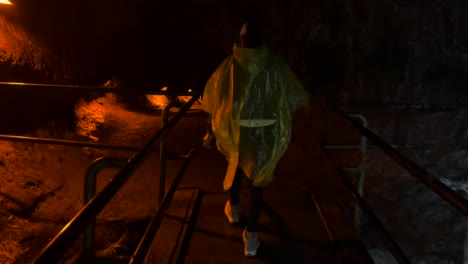 Mauna-Loa-volcano-in-Hawaii,-woman-walking-into-dark-tunnel