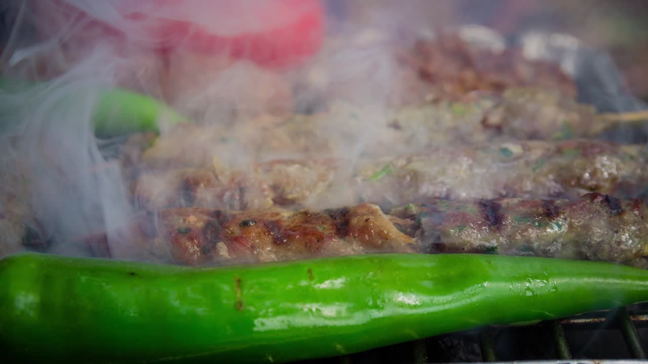 Cinemagraph di fumo emesso dalla cottura di diversi tipi di carne su una griglia BBQ calda