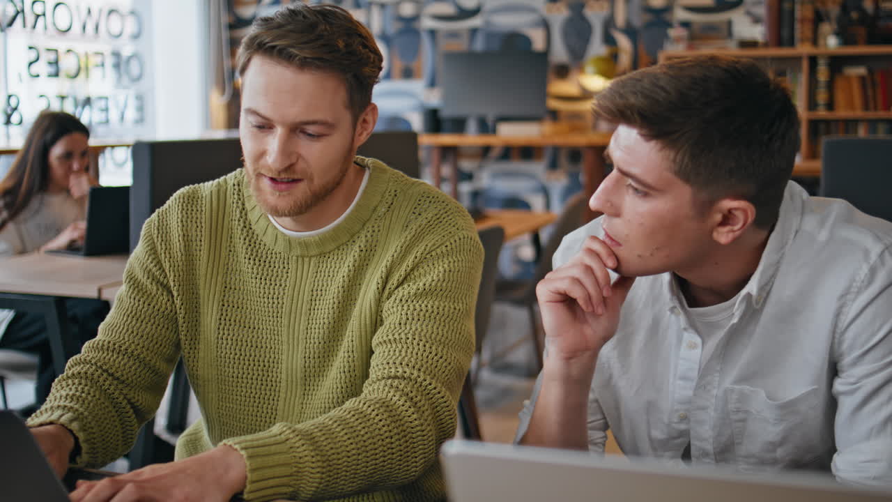 Creative colleagues using computers collaborating in boardroom at office closeup