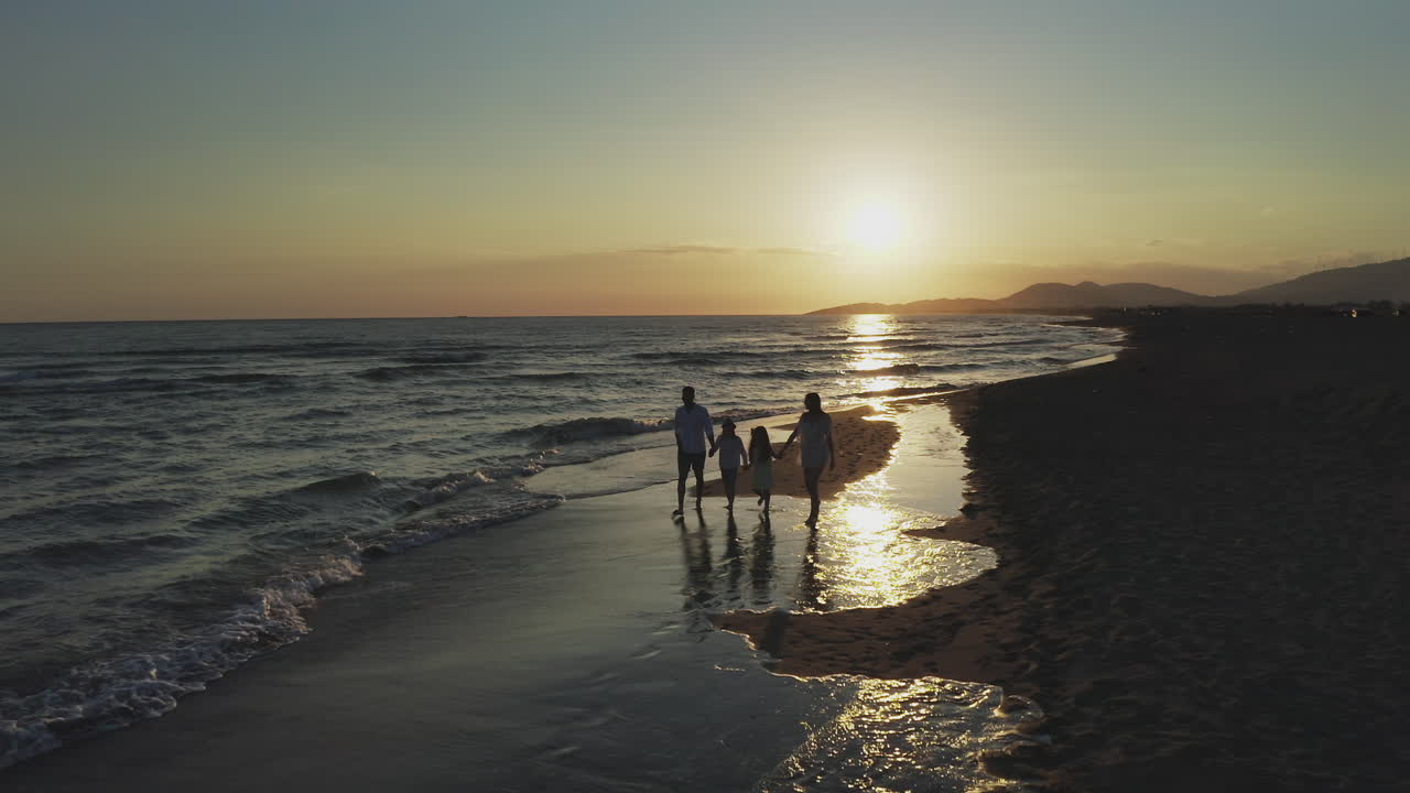 familia disfrutando de un paseo por la playa al atardecer