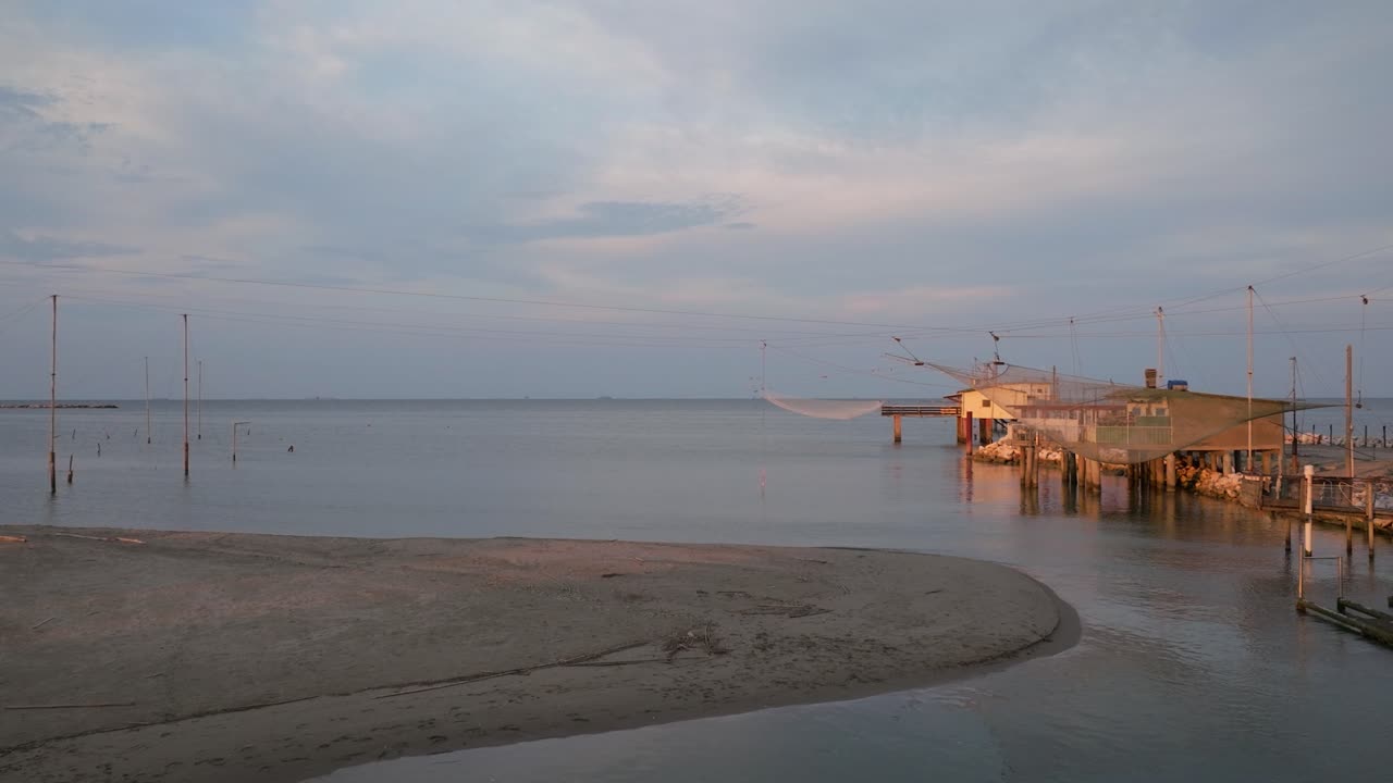 vista aérea de cabañas de pesca a orillas del estuario al atardecer, máquina de pesca italiana, llamada "trabucco", lido di dante, ravenna cerca del valle de comacchio-2