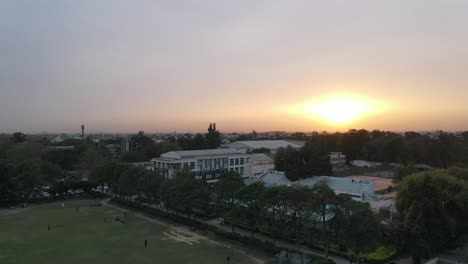 4K-Drone-Shots-of-a-Sunset-in-an-Indian-City-New-Delhi-above-trees-and-houses-beautiful-light-punjabi-bagh-club-posh-colony