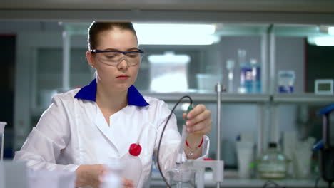 científica que trabaja con equipos en un laboratorio químico