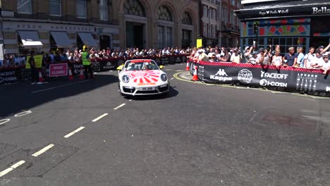 ford mustang police car and beautiful porsche cruising on london roads and presenting cars during gumball3000 outdoor show.