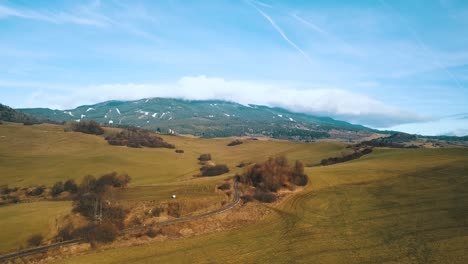 drone shot over hills with mountain and clouds