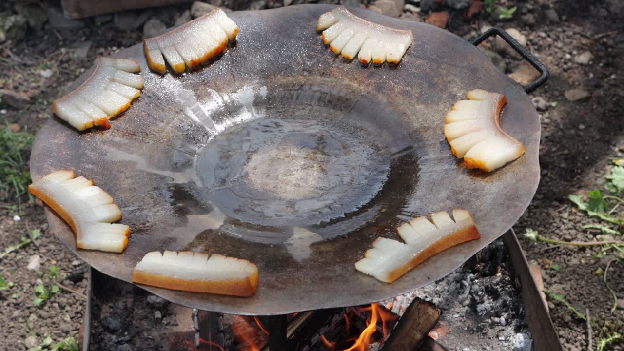 살로나 의 조각 들 이 불 위 에 있는 그릴 디스크 에  ⁇ 어지고, 지방 이 중앙 으로 녹는다