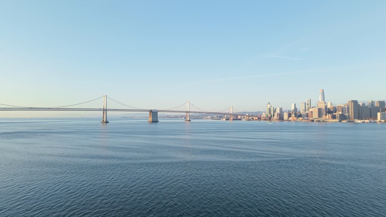 Patterns of steel and concrete meet soft clouds and open water in this composed aerial of San Francisco’s edge.