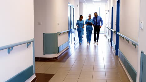 Doctor-and-nurses-discussing-over-clipboard