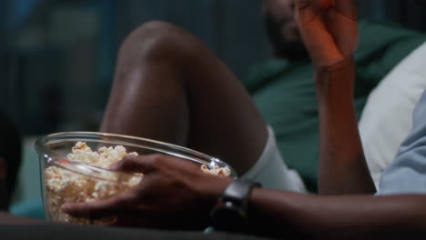 amigos disfrutando de una noche de películas con palomitas de maíz
