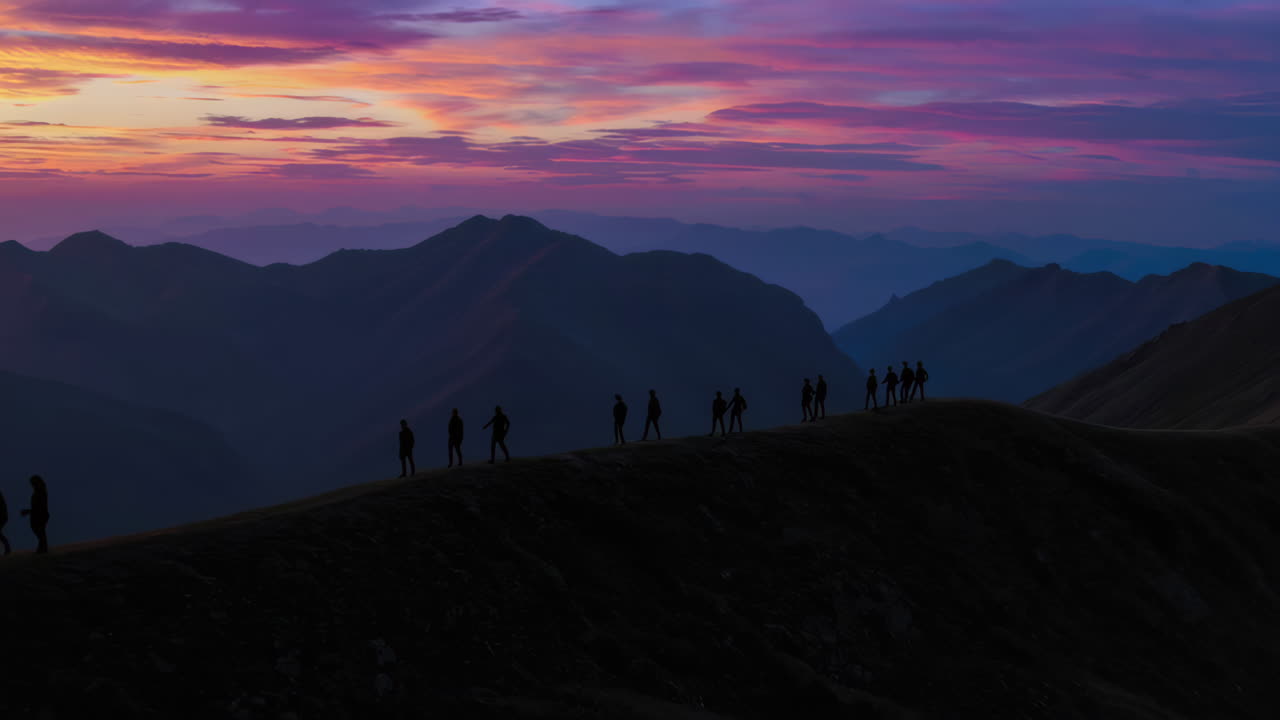 Silhouette of Hikers at Sunrise Mountain Peak