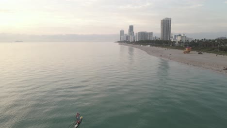 La-Antena-Supera-A-Un-Surfista-Solitario-En-Una-Playa-De-Arena-Mientras-Miami-Se-Despierta