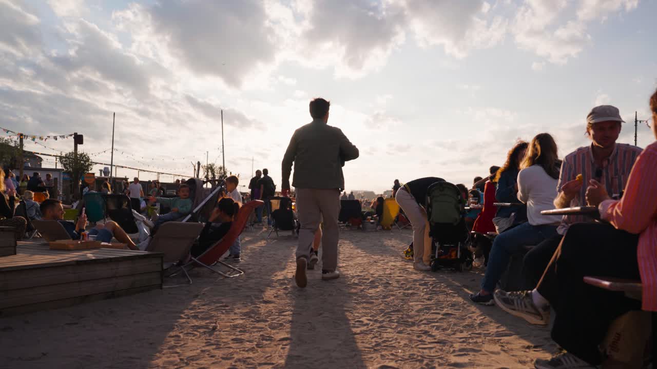 Bright evening sunlight during public gathering on beach, Copenhagen